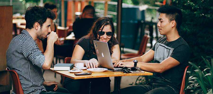 Three people conversing at a table.